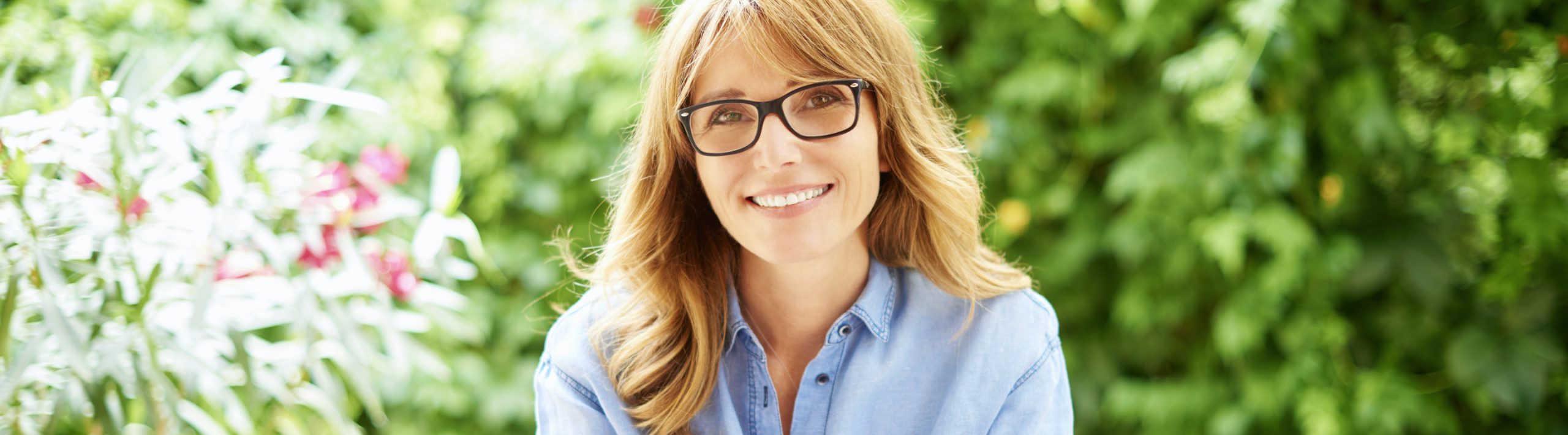 Woman with glasses in garden.
