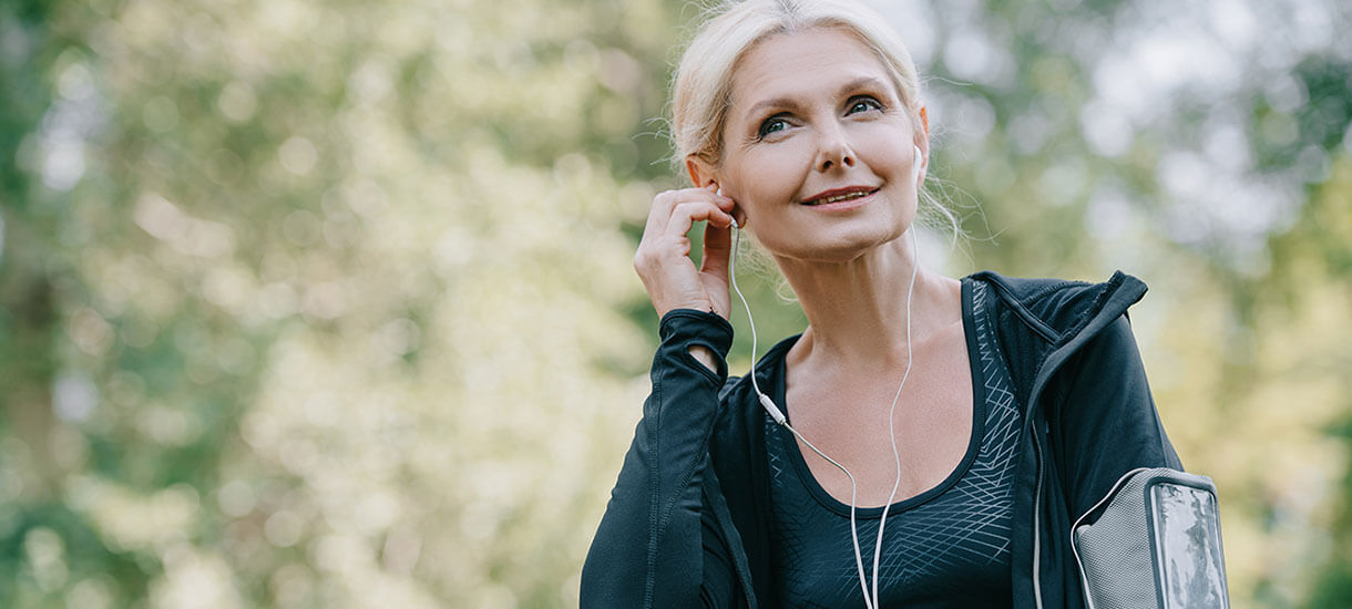 Recovering gut health patient listens to a podcast while exercising outdoors.