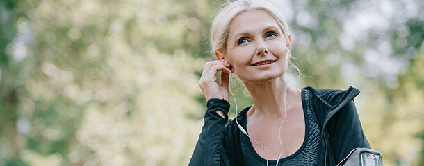 Recovering gut health patient listens to a podcast while exercising outdoors.