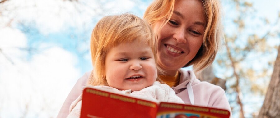 Mother reads to young child with autism who has been helped with MeRT therapy