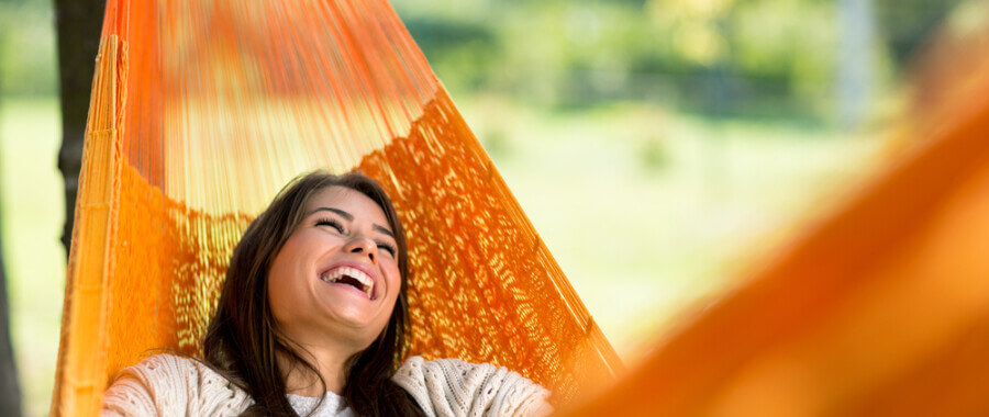 Happy woman in hammock outside having used MeRT Treatment for depression and anxiety.