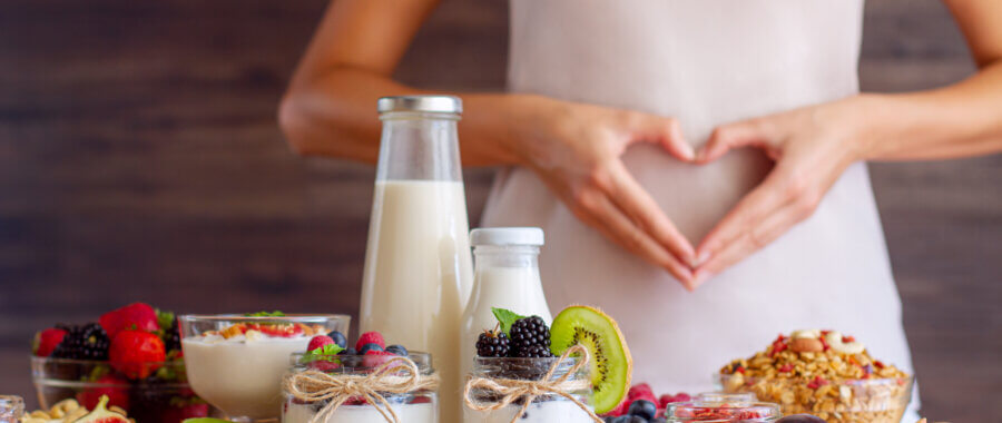 woman making a shape with her hand around some fruits