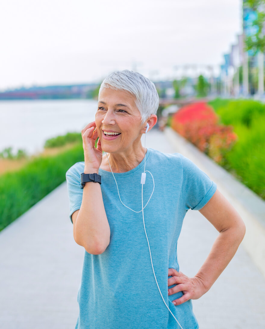 Woman with earbuds on a walk.