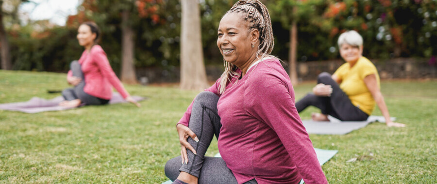 a group of women doing yoga in a park