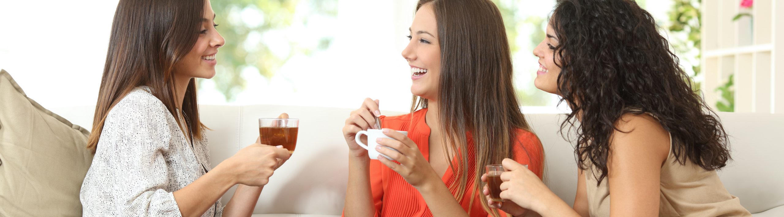 Three women chat and have tea.