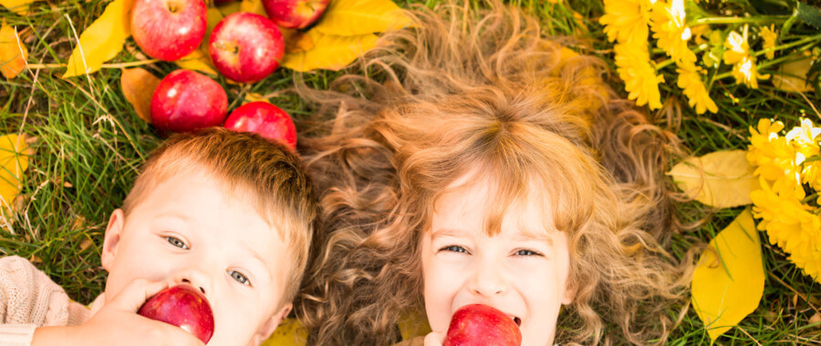 kids eating apples in autumn